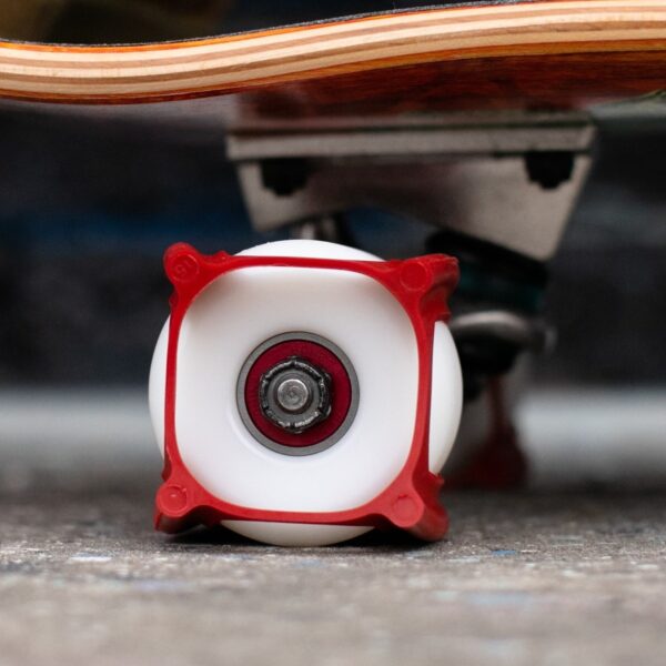 White skateboard wheel with red Skater Trainers and bearings.
