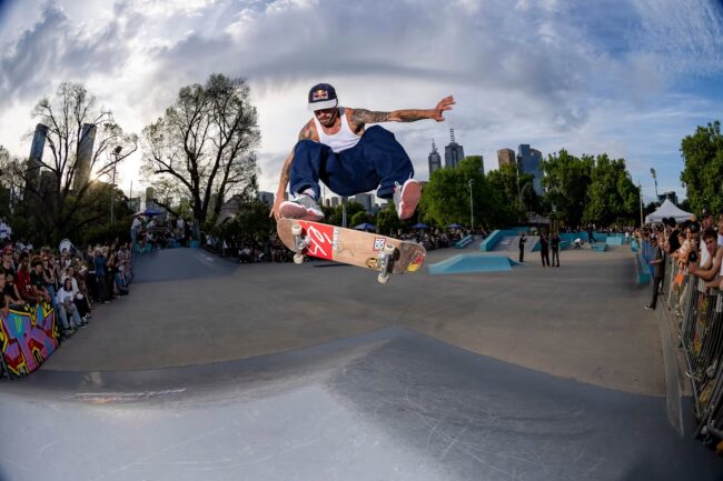 Gustavo Ribeiro performs a flip trick over a hip at a skate demo in Melbourne's Riverslide Skatepark.